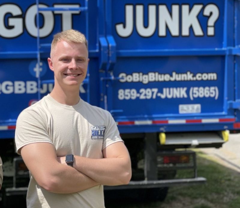 Go Big Blue Worker Smiling by Truck